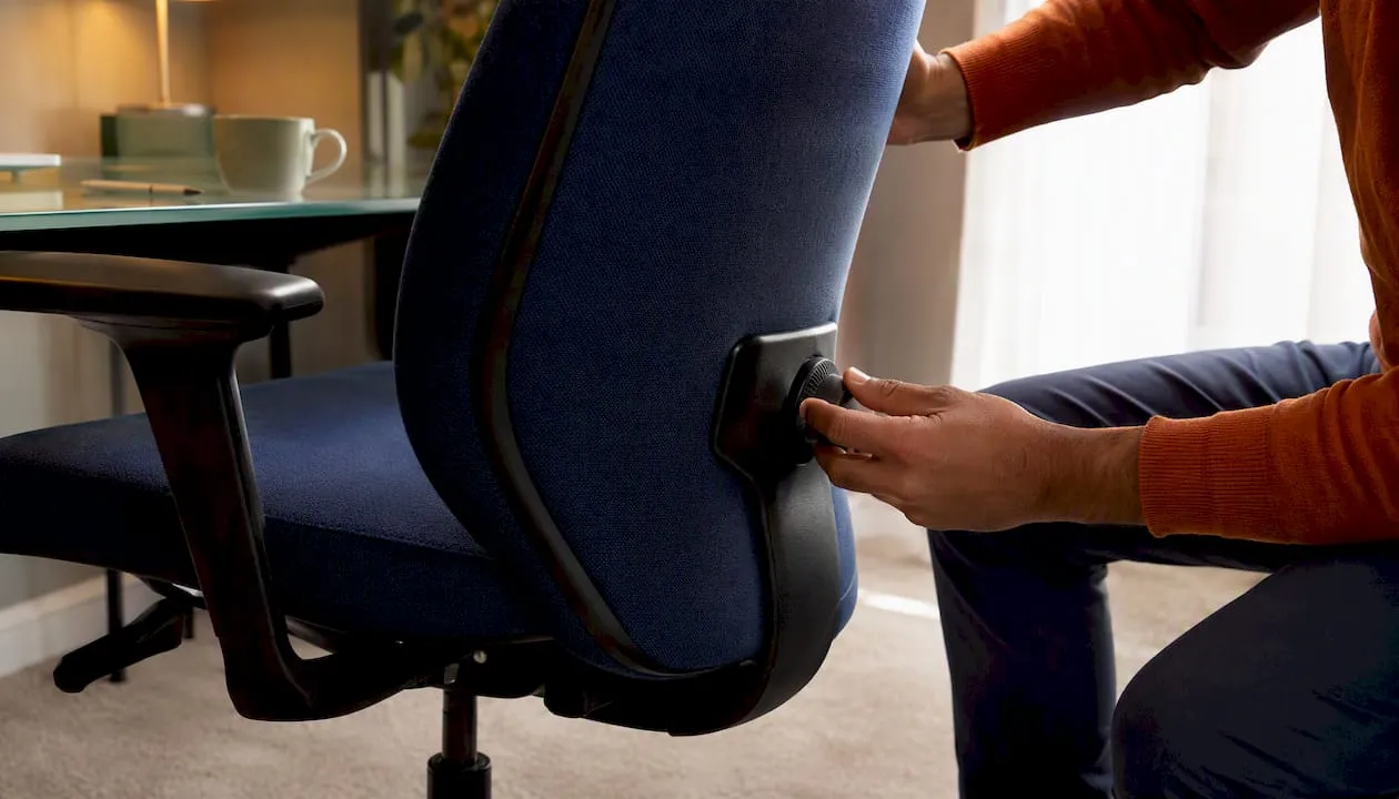 Hands adjusting lumbar support on fabric chair