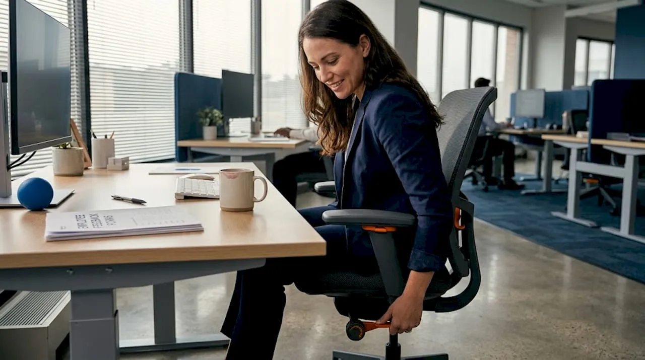 Office worker adjusting ergonomic chair at desk