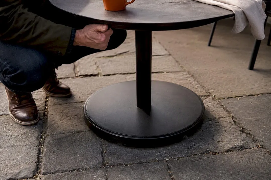 Weighted café table base on uneven paving