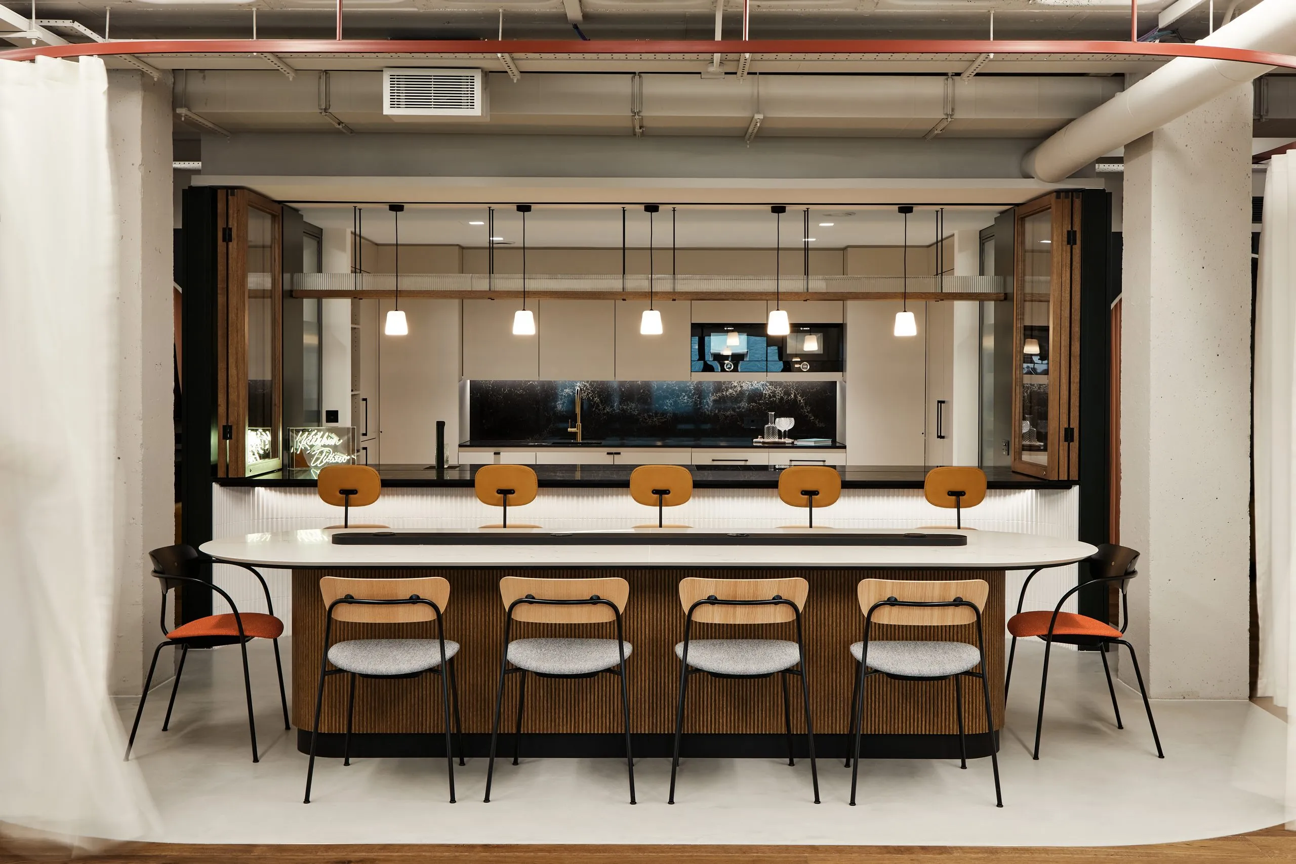 Office kitchen with a breakfast bar and timber stools
