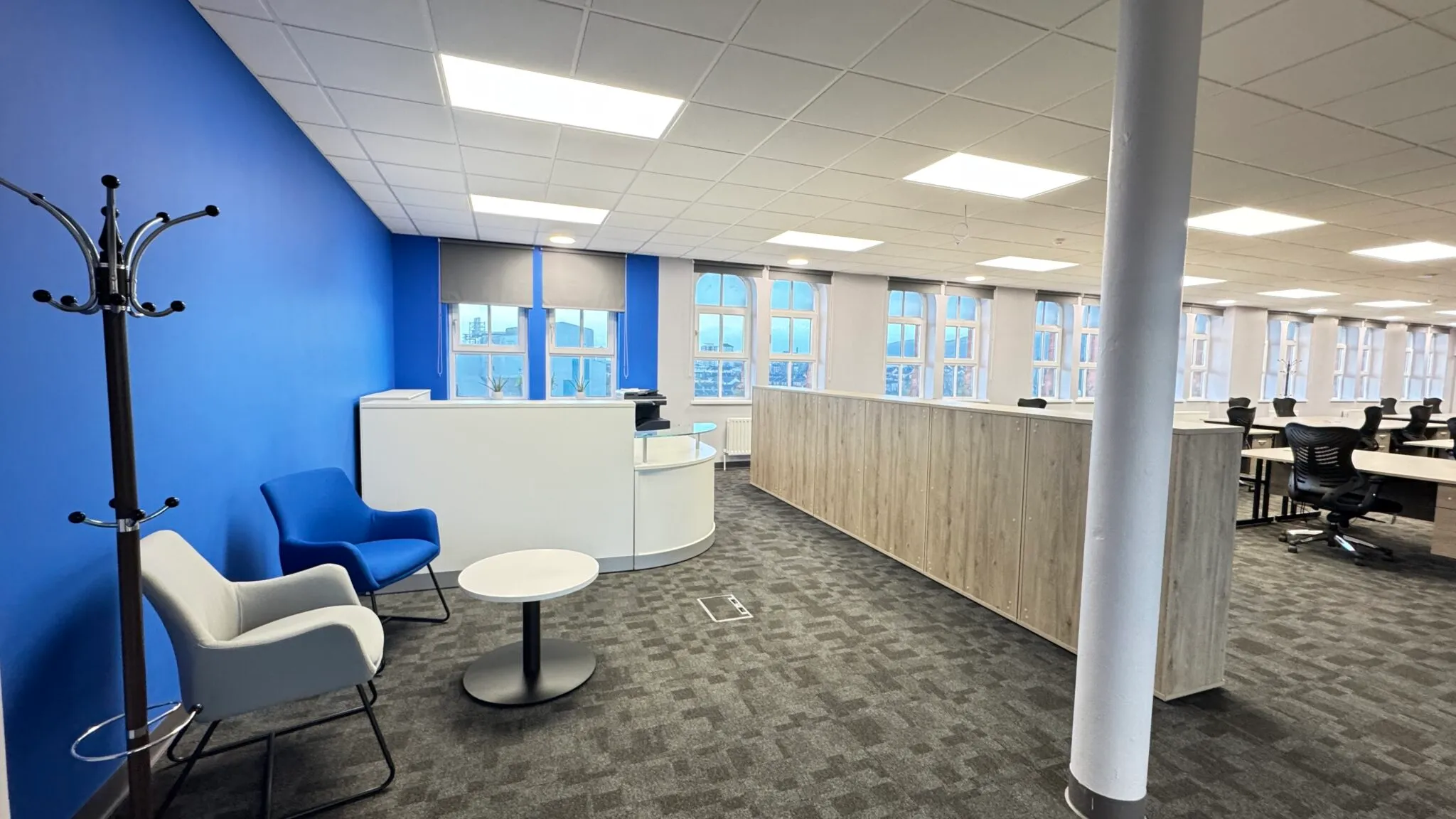 Reception area with blue armchairs and a white reception desk