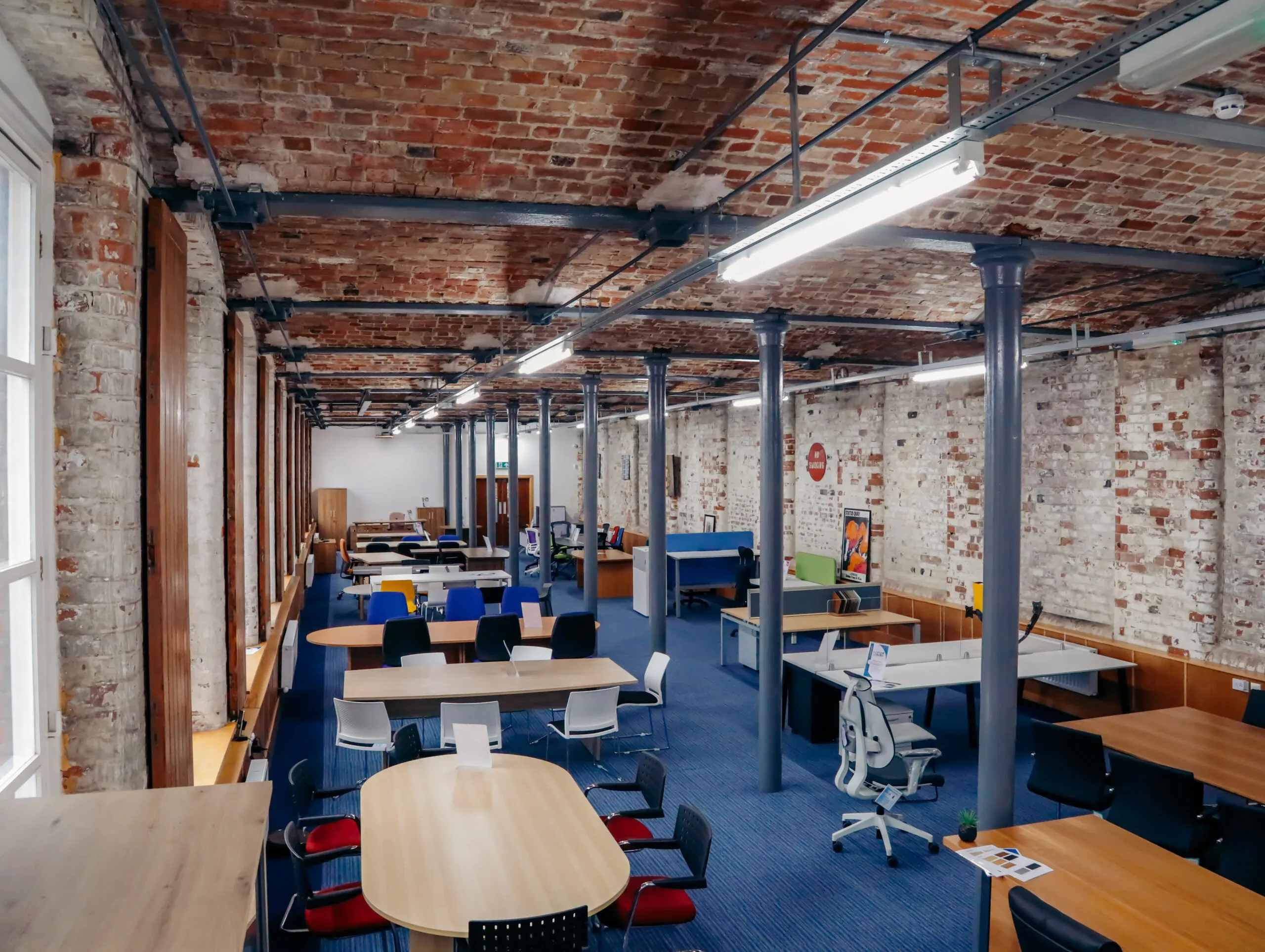 Long view of the vaulted brick showroom with cast iron pillars