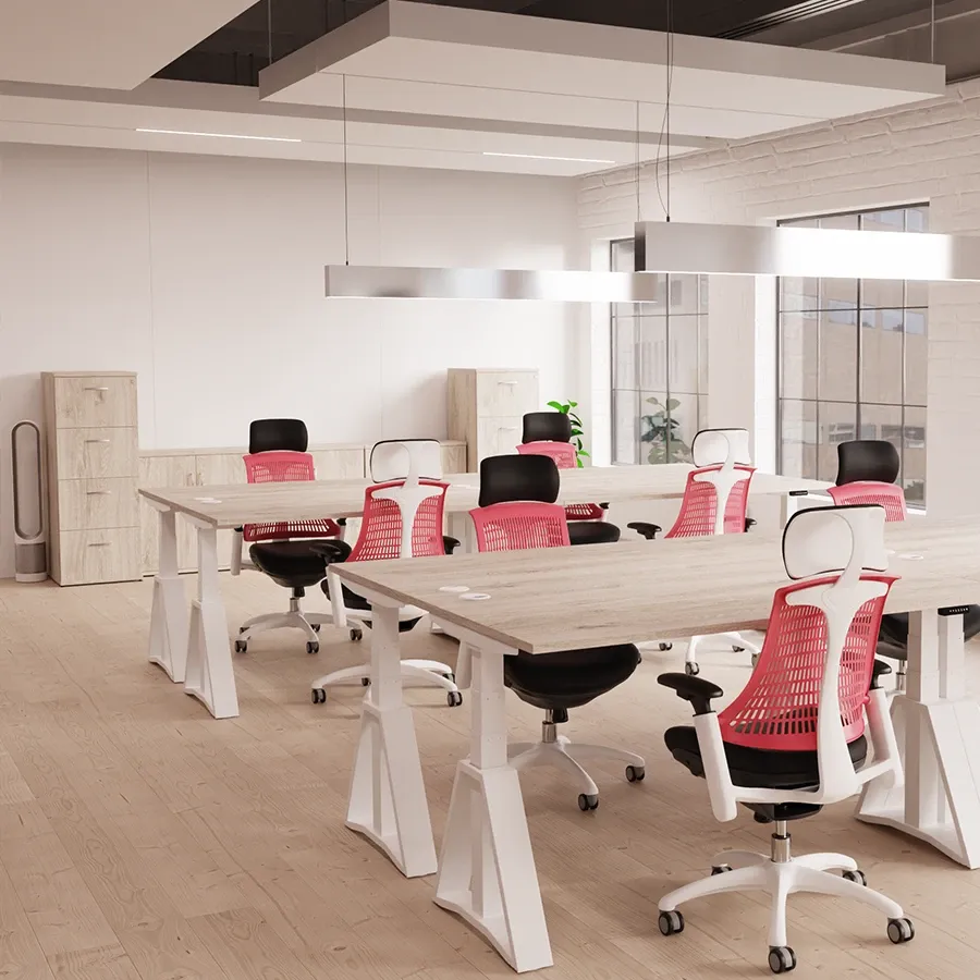 Bench desks with red mesh chairs in a bright office