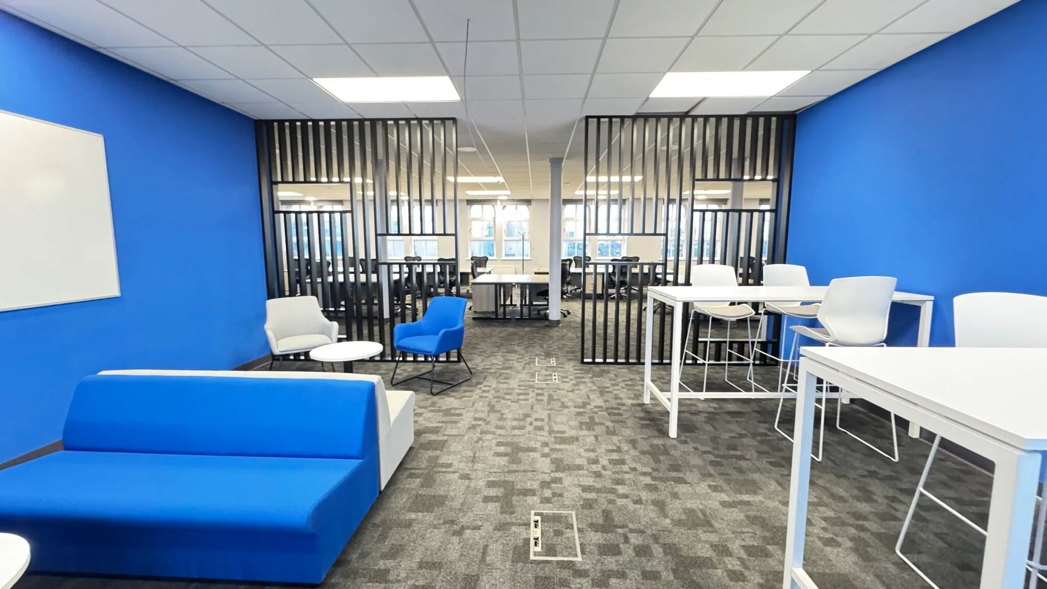 Breakout area with a blue sofa and a slatted screen