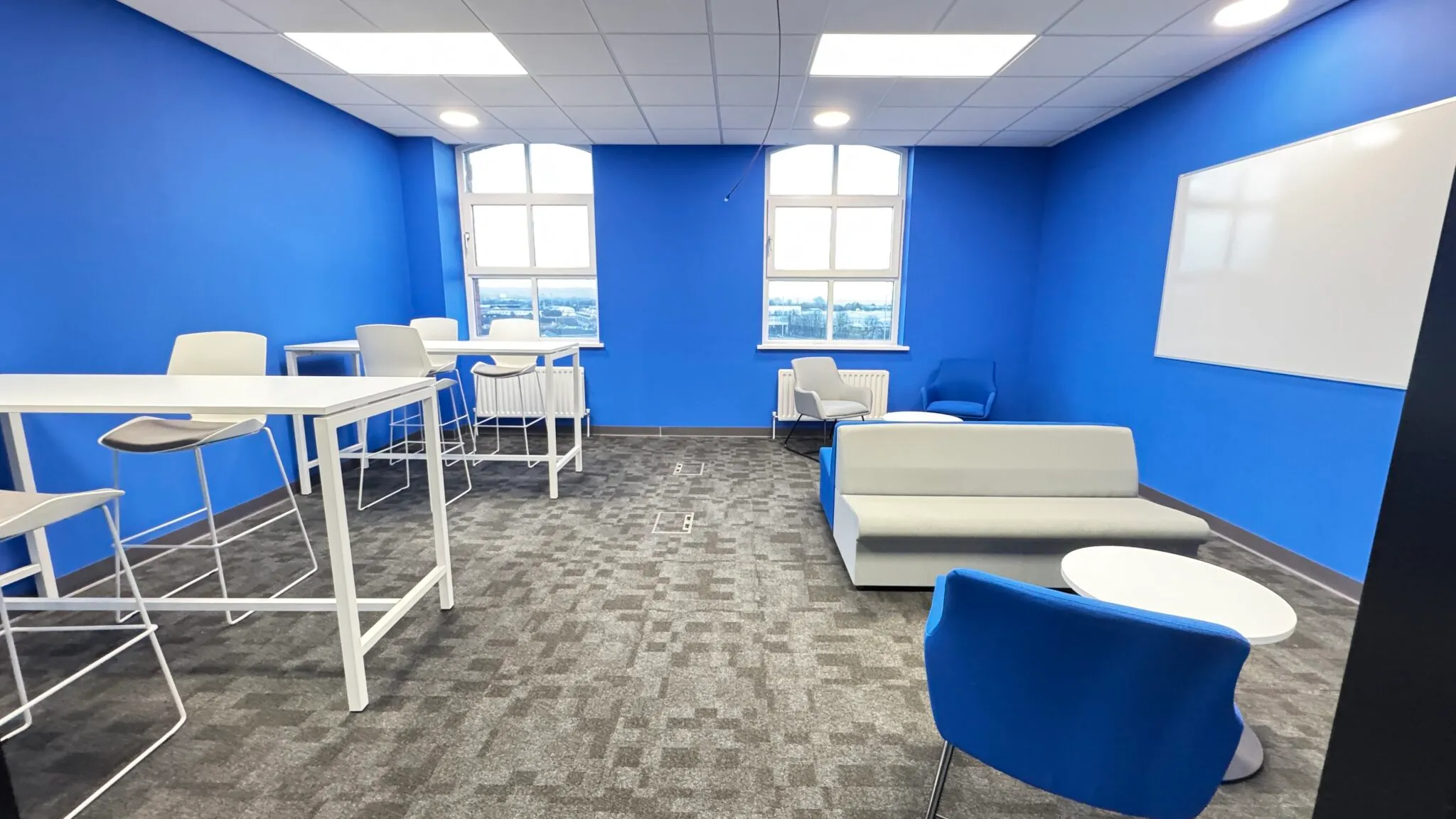 Breakout area with poseur tables and a blue armchair