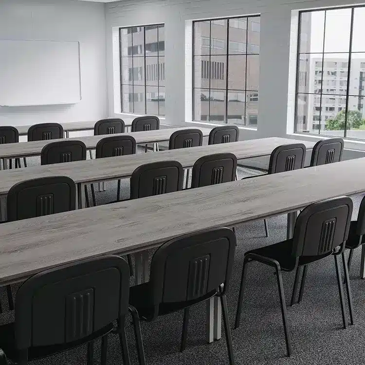 Classroom with rows of grey tables and black chairs