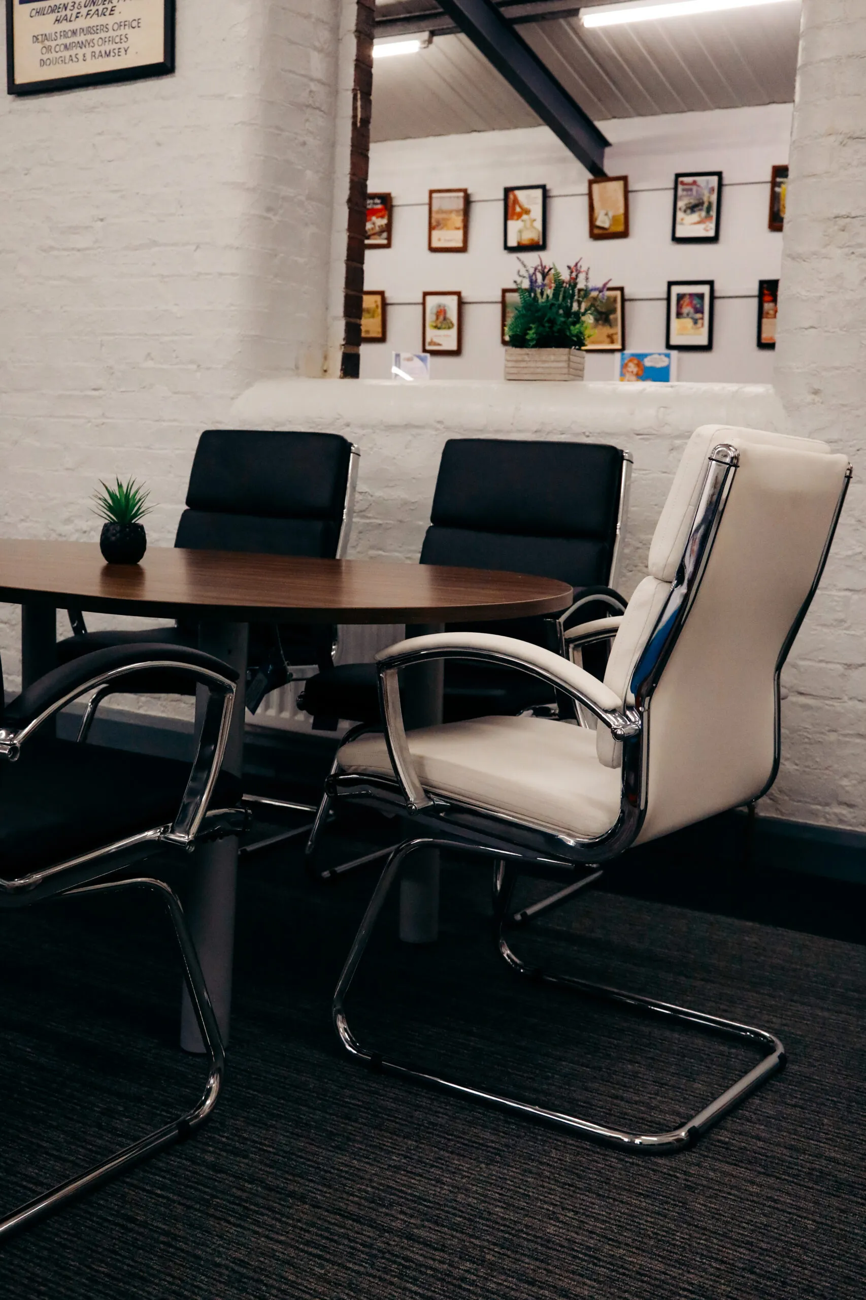Dark wood meeting table with black and white cantilever chairs