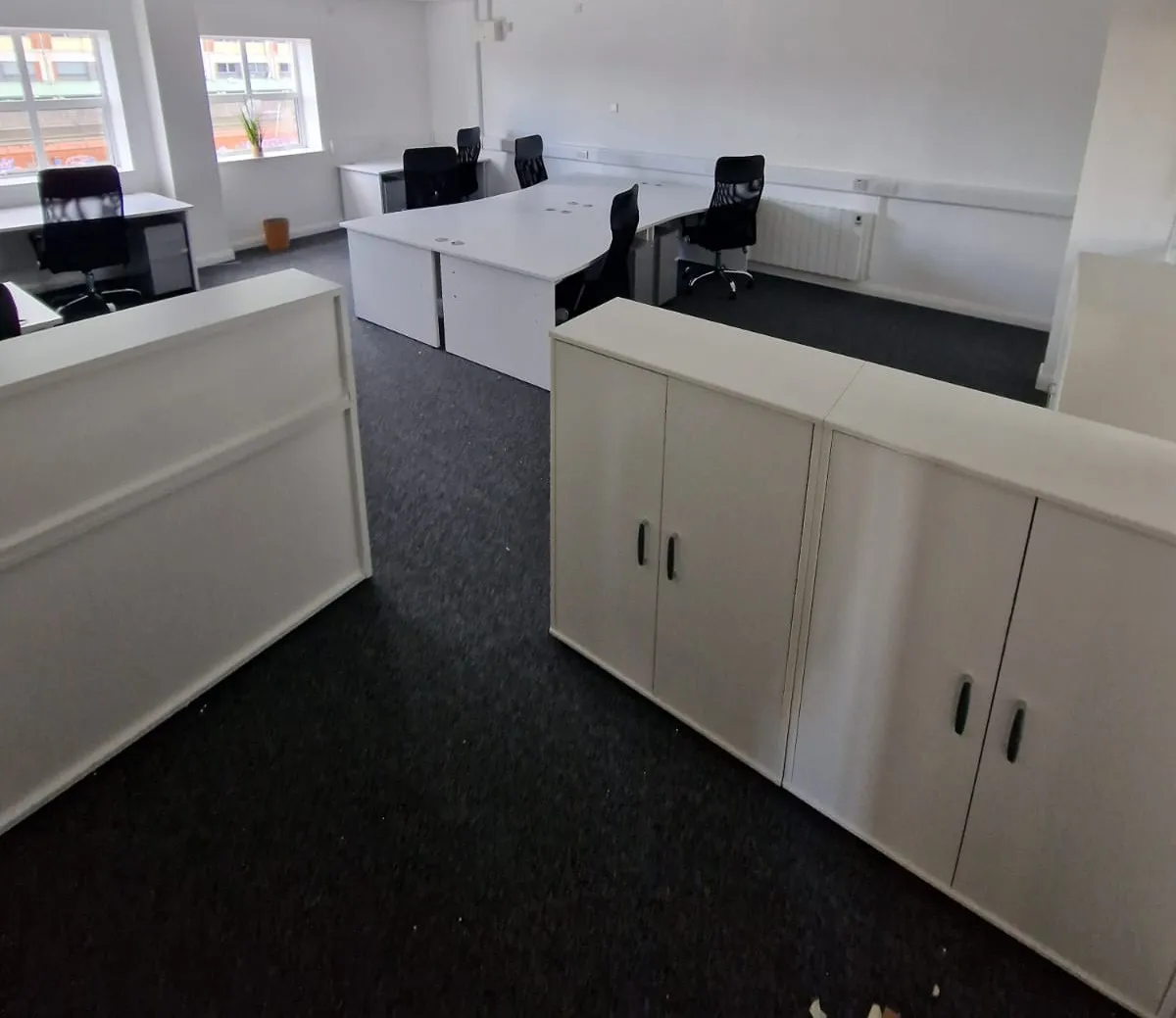 White storage cupboards dividing the open-plan office