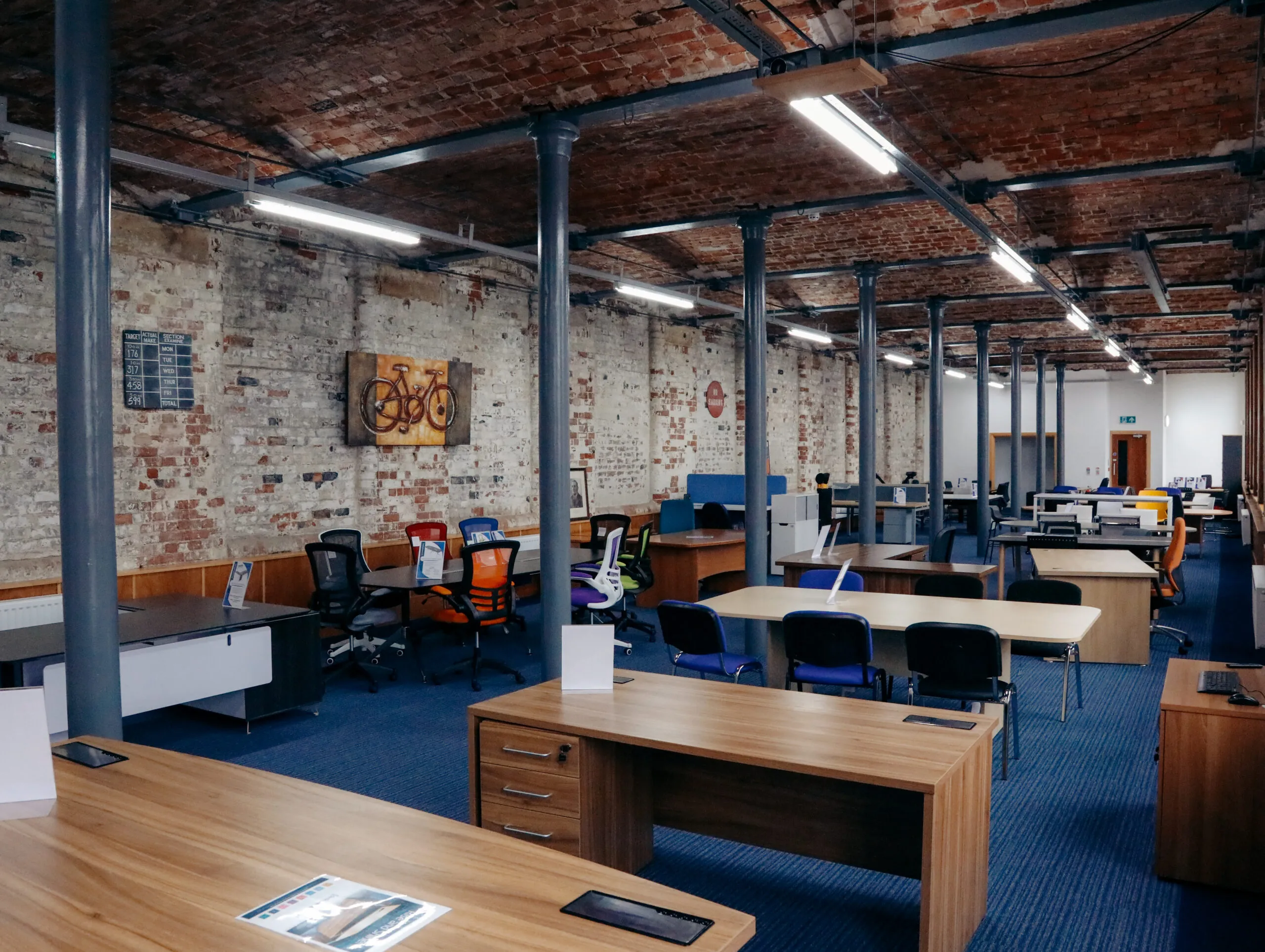 Vaulted brick showroom with desks and storage