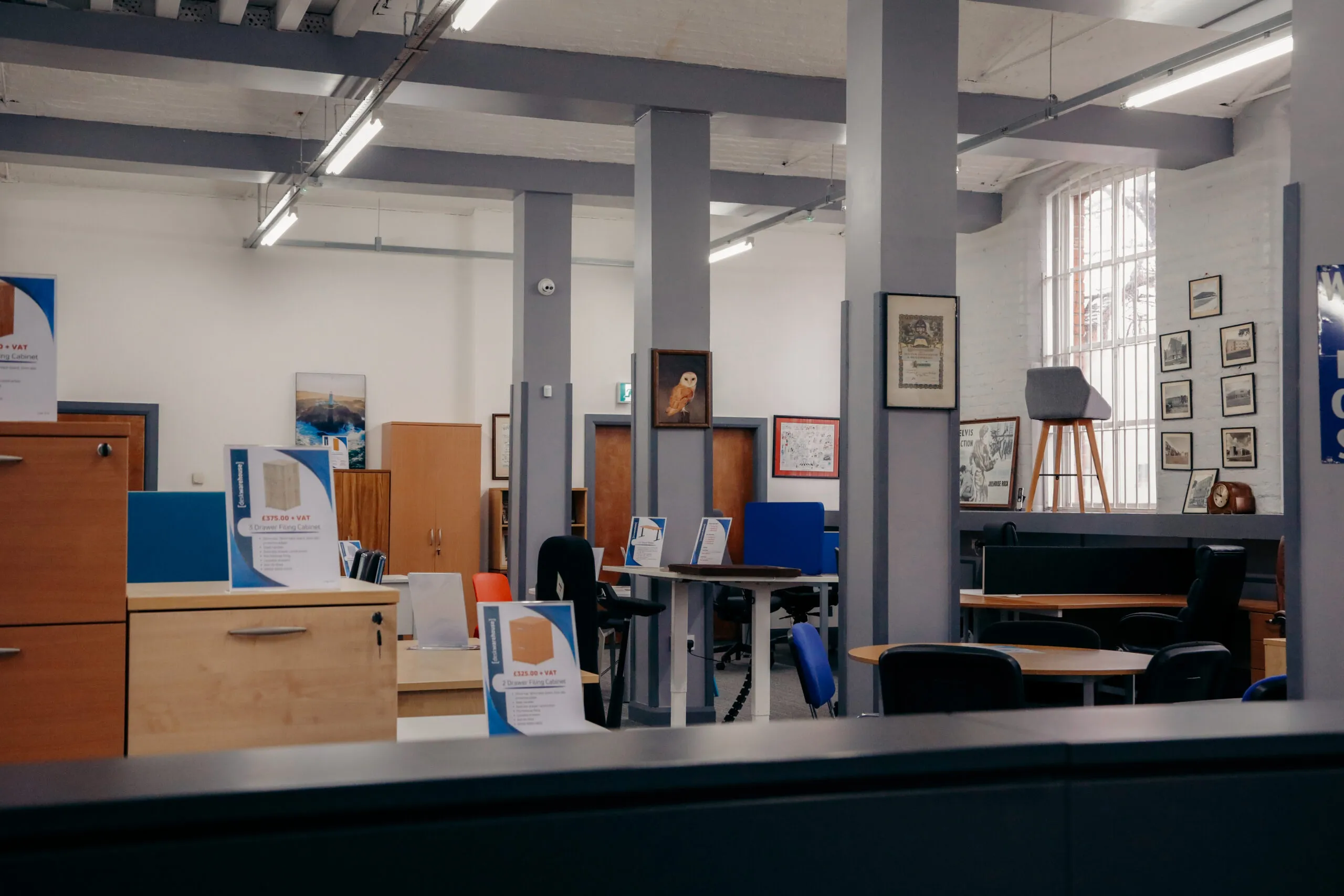 Wide view of the showroom with desks, cupboards and chairs