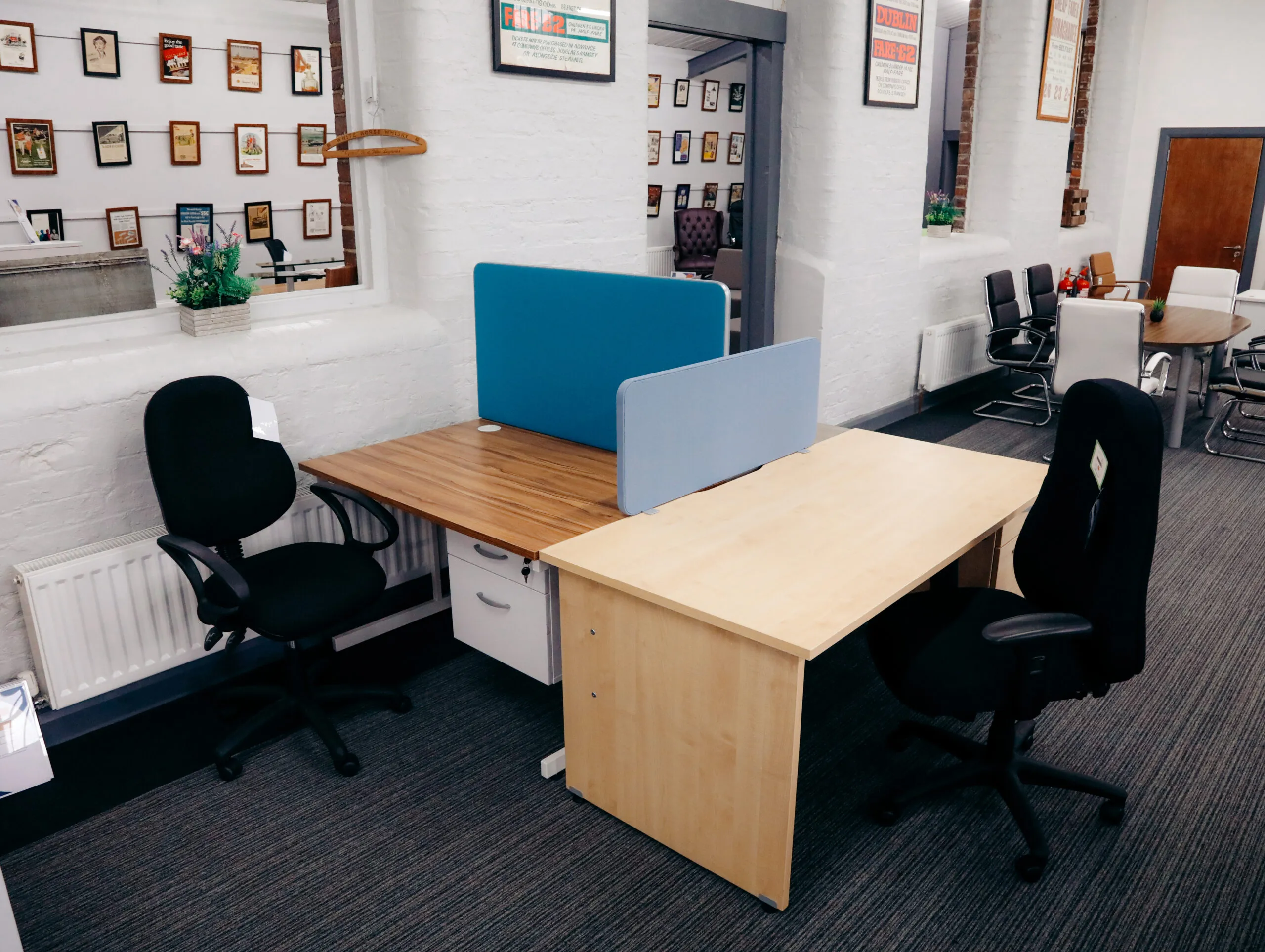 Beech desks with blue desk screens and black operator chairs