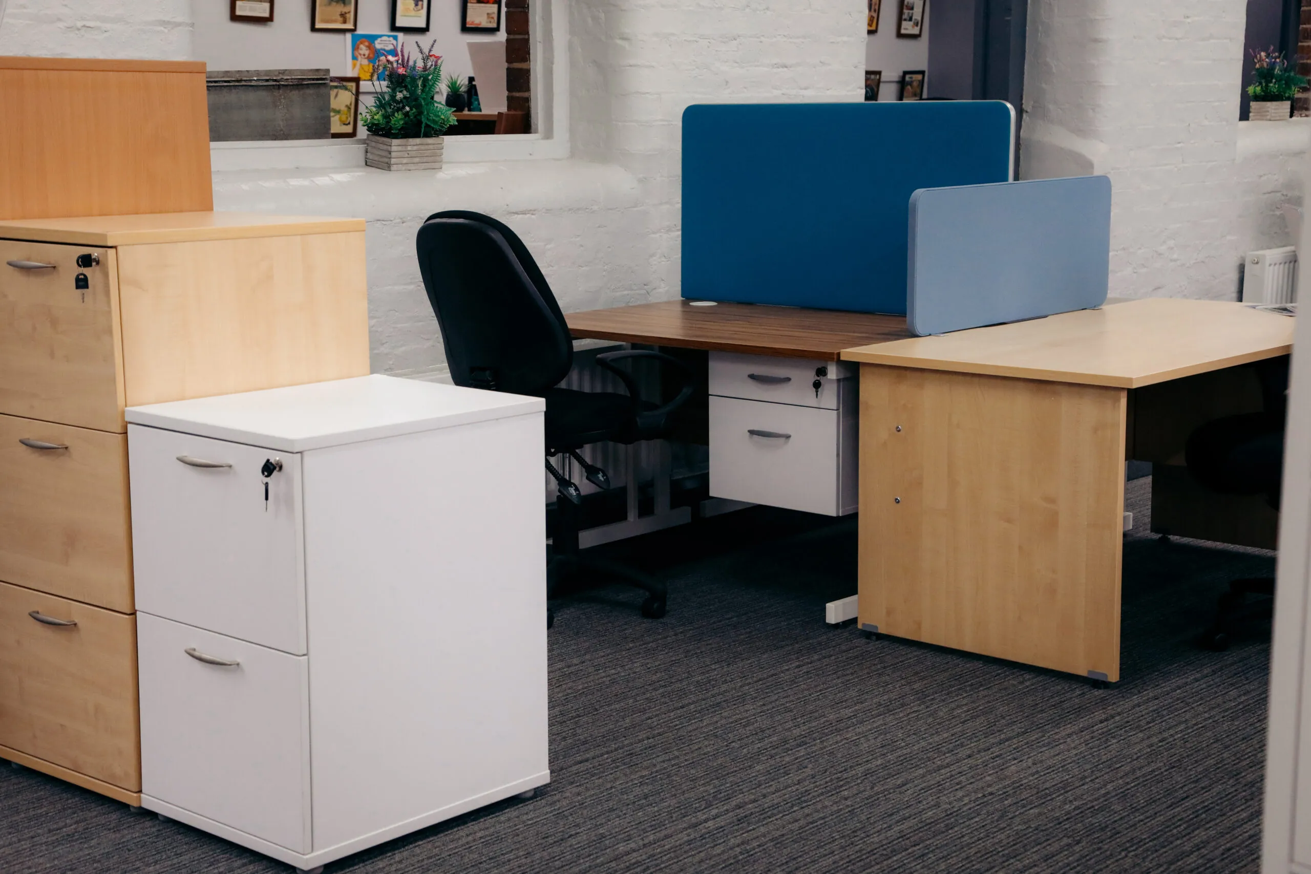 White and beech pedestals beside desks with blue screens
